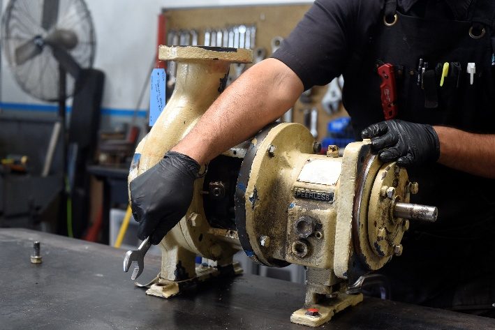Technician positioning the pump for teardown