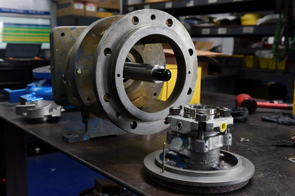 Assembled bearing frame with shaft installed, seal gland staged alongside