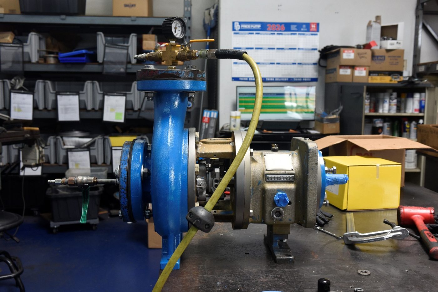 Rebuilt pump connected to a gauge and hose for hydrostatic pressure testing